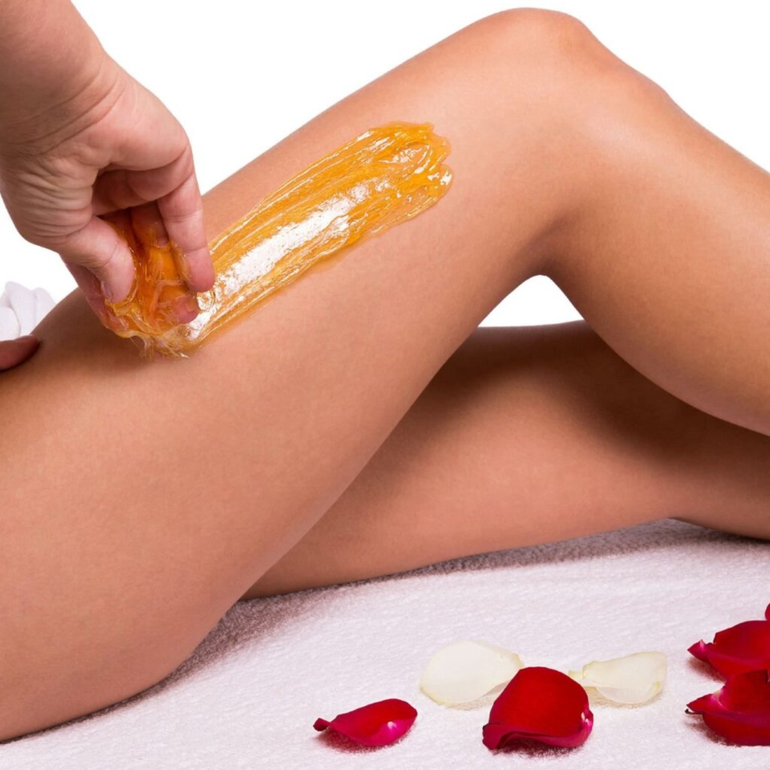 Sugar paste being applied smoothly along the leg during a sugaring treatment